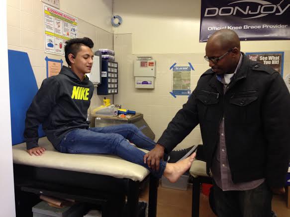 EJ evaluates a student’s ankle after he was hurt playing soccer during lunch. 