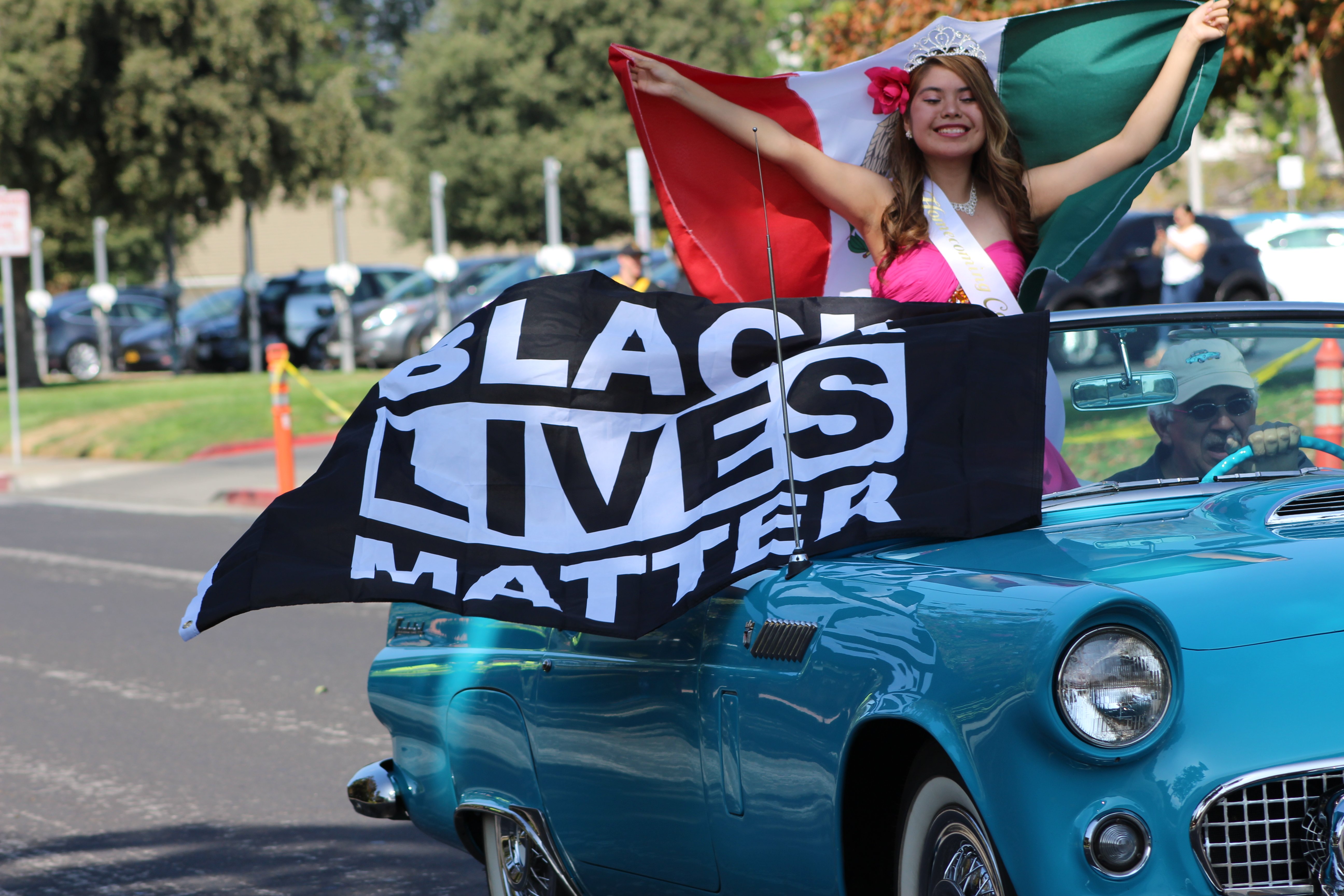 Lawrence holds a Black Lives Matter flag in car alongside homecoming partner Jasmine Velazco. Photo by Nisha Malley.