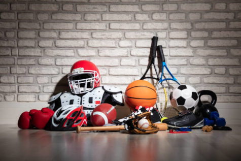 Various Sport Equipment On Floor In Front Of Brick Wall